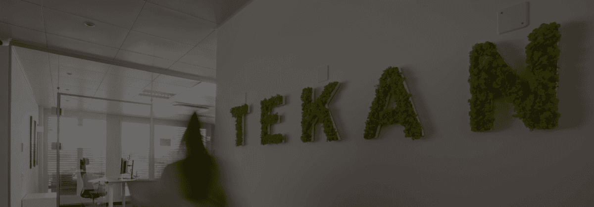 Person läuft an der Tekan Wand vorbei.