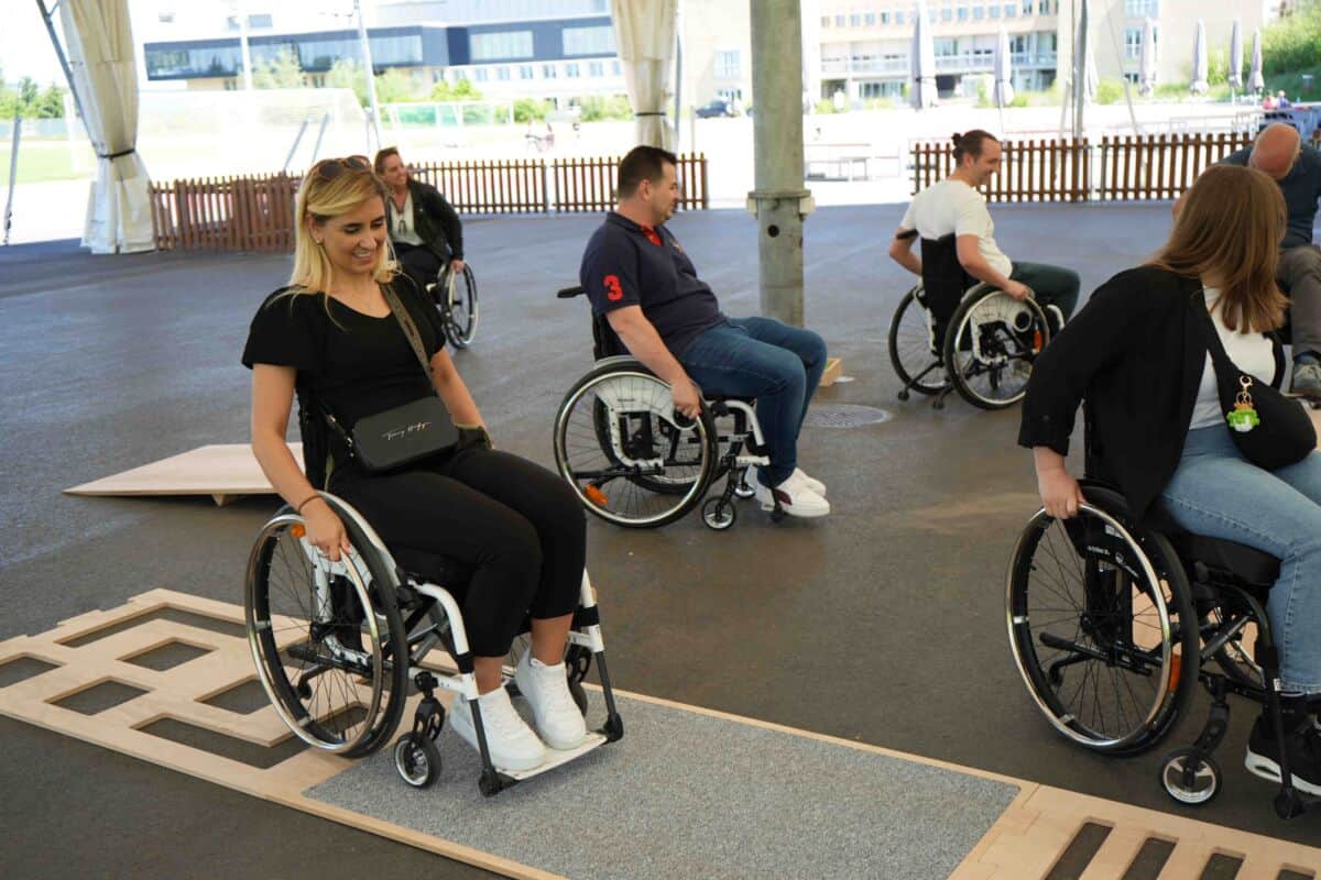 Einheits-Akrtionstag-schweizer-paraplegiker-zentrum_4 Mehrere Mitarbeiter, die ein Rollstuhl Parkur machen.
