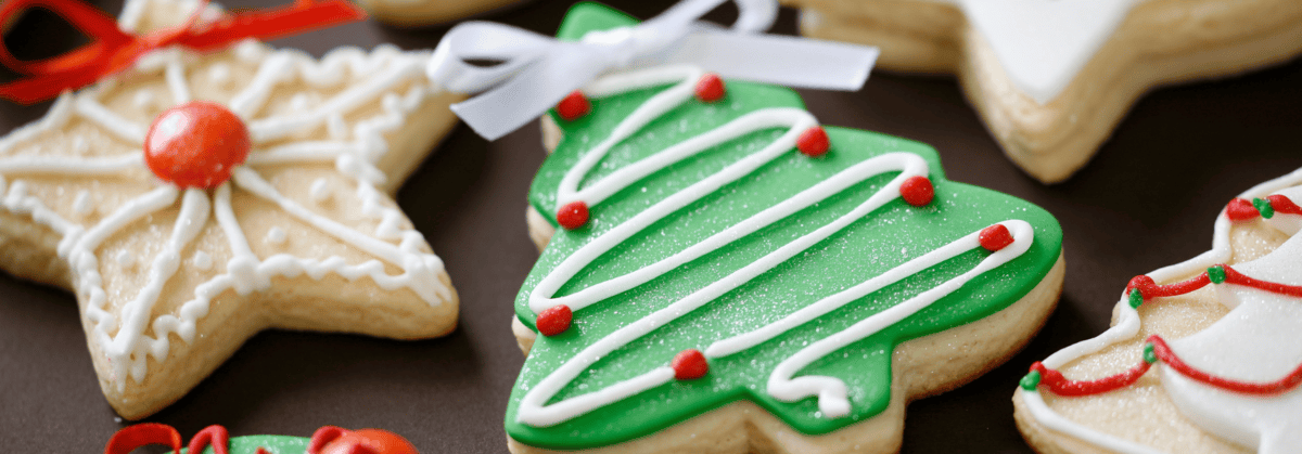 Weihnachtlich dekorierte Kekse in Stern und Tannenbaumform, verziert mit farbigem Zuckerguss.