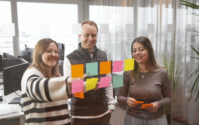 3 Personen legen ein Konzept mit Post-It